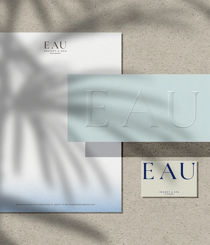 Branding by Spherical 18 Branding set for EAU Resort & Spa with letterhead, business card, and embossed card on textured surface.