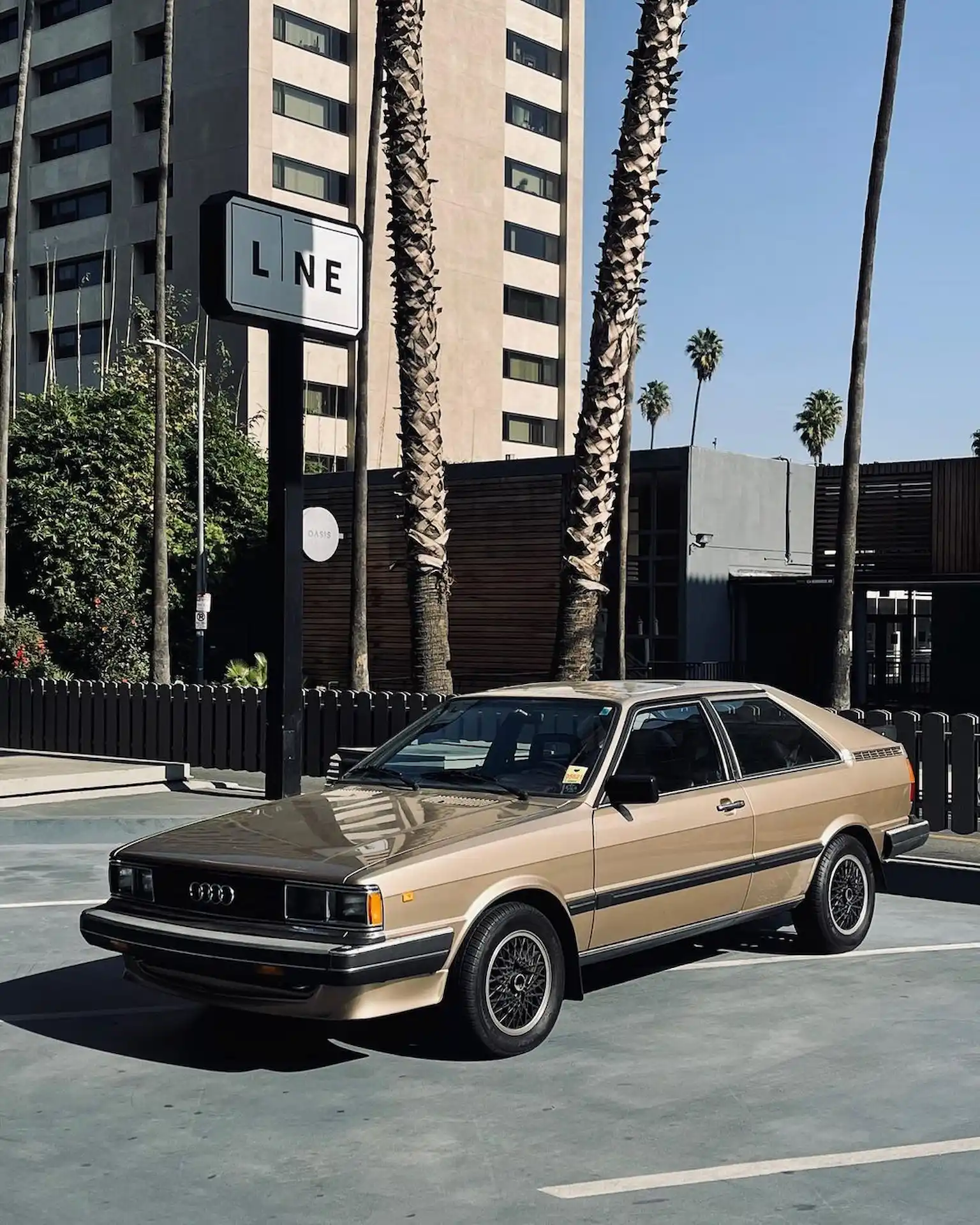 The LINE 3 Vintage Audi parked in front of The LINE hotel sign with tall palm trees in the background