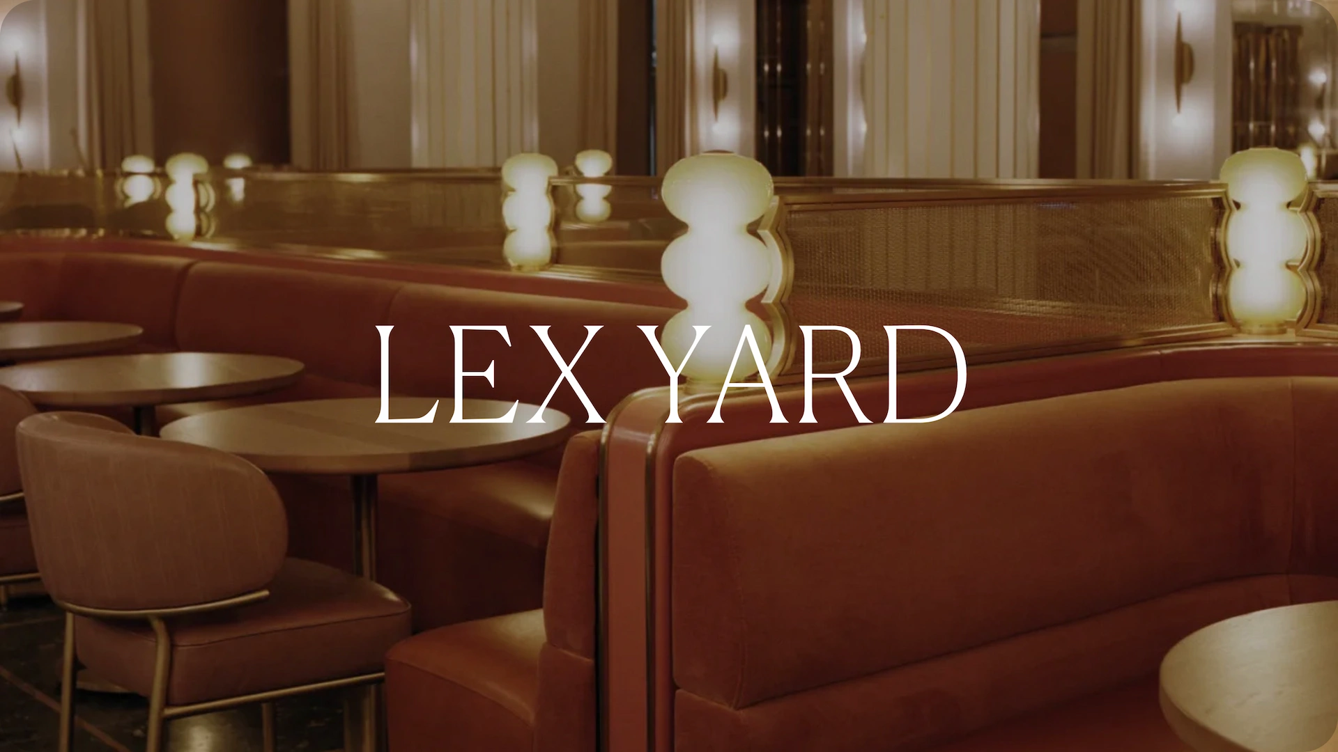Upscale restaurant interior with brown booths, round tables, glowing lamps, and “LEX YARD” branding.