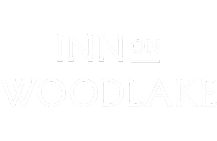 Branding by Spherical 8 Alt text: White “INN on WOODLAKE” logo on a transparent background